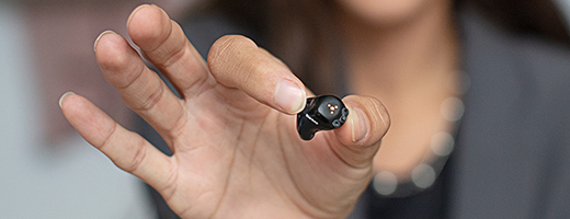 Image of hands presenting a custom hearing aid